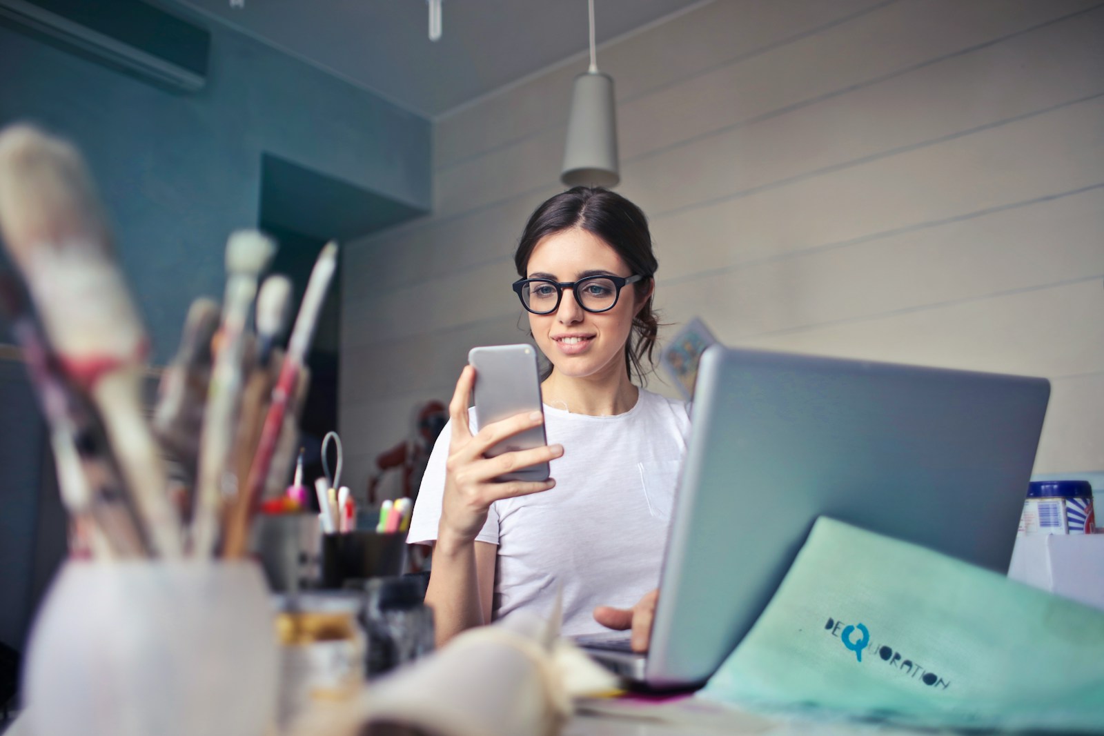 woman in white shirt using smartphone to ensure she has business interruption insurance